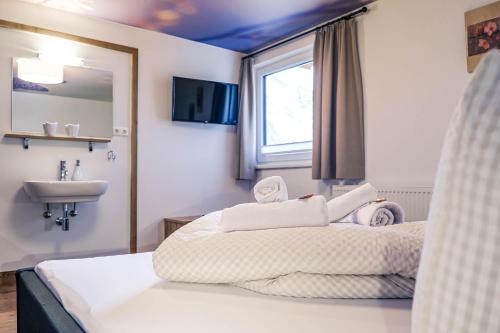 a bedroom with a large bed and a sink at Haus Kristall in Tannheim