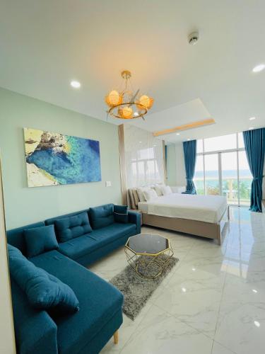 a living room with a blue couch and a bed at Sealiks Ocean vita muine C326 in Phan Thiet