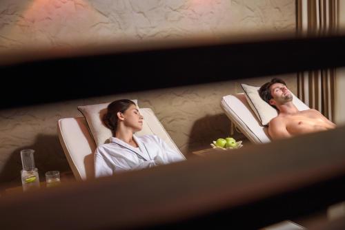 a man and woman sitting in chairs in a hotel room at Anatolia Hotel in Thessaloniki