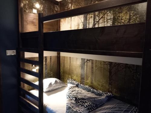 um quarto com um beliche e papel de parede da floresta em Ristafallet em Åre