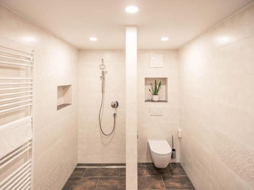 a white bathroom with a shower and a toilet at Haus Kristall in Tannheim