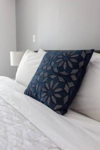 a white bed with a blue pillow on it at Super Cool 1BR Apartment in Brickell with Parking in Miami