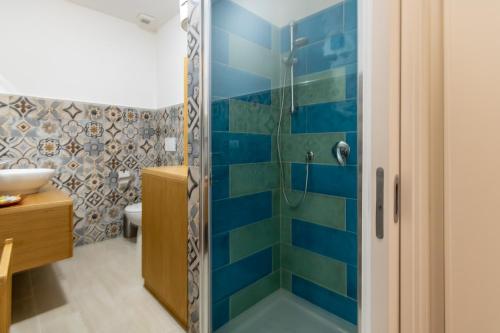uma casa de banho com um chuveiro com azulejos azuis em HC Home Claudia em Cagliari