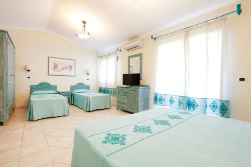 a hotel room with two beds and a tv at Hotel Baia Aranzos in Pittulongu