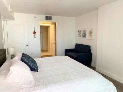 a bedroom with a large bed and a blue chair at Super Cool 1BR Apartment in Brickell with Parking in Miami