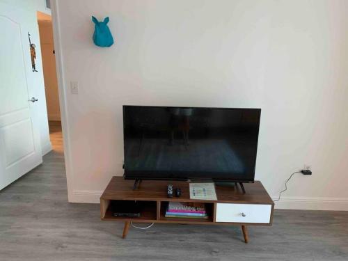 a flat screen tv sitting on top of a wooden table at Super Cool 1BR Apartment in Brickell with Parking in Miami