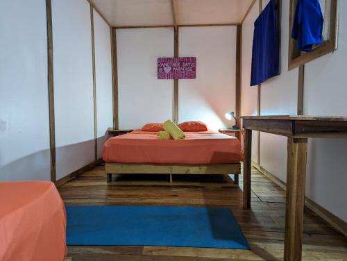 a small room with a bed and a table at Arboura Eco Cabins in Uvita