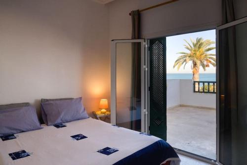 a bedroom with a bed and a view of the ocean at Appartement avec Terrasse VUE MER in La Marsa