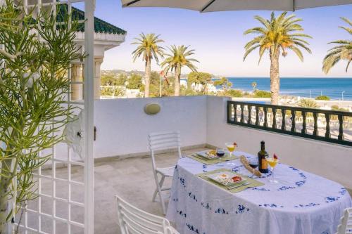 a table on a balcony with a view of the ocean at Appartement avec Terrasse VUE MER in La Marsa