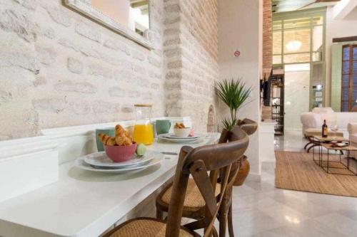 a dining room with a table with food on it at Judería de Sevilla I Luxury Apartments in Seville