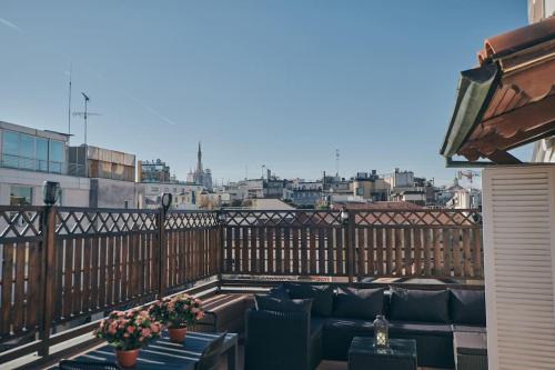 balcón con sofás y vistas a la ciudad en Sant’Andrea Penthouse by Montenapoleone Living, en Milán