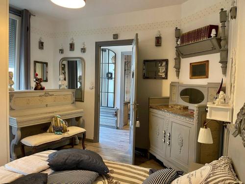 ein Wohnzimmer mit einem Bett und einem Klavier in der Unterkunft Maison de l'Horloge in Riorges
