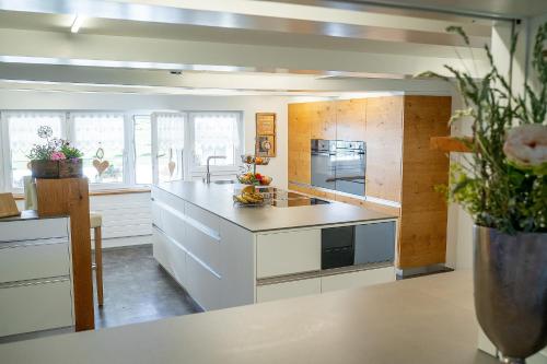 uma cozinha com armários brancos e uma bancada em Gästehaus Aemisegg em Sankt Peterzell