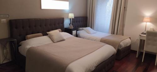 a hotel room with two beds and a window at "La Selvetta" bed and breakfast in Buguggiate