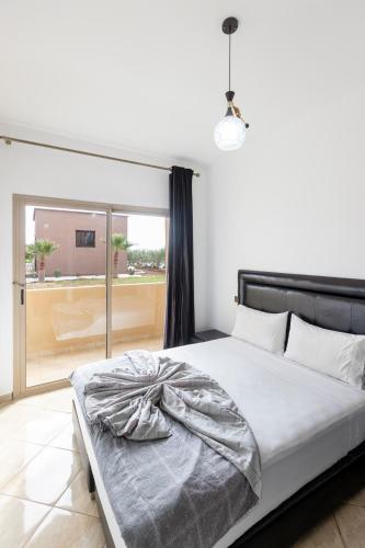 a bedroom with a bed and a large window at lafamilia in Marrakech