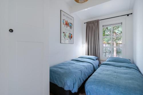 twee bedden in een kamer met een raam bij Boshof 7 in Ermelo