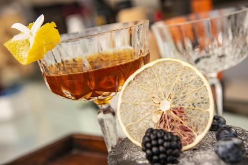 a drink and a lemon slice on a table at Hotel Signum in Malfa