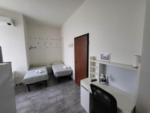 a small room with two beds and a desk at Masco apartments in Milan