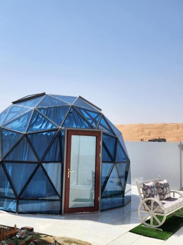 a blue dome house with a bench and a chair at Blue Dome Chalet شاليه القبة الزرقاء in Al Raka