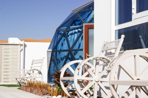 a group of chairs sitting outside of a building at Blue Dome Chalet شاليه القبة الزرقاء in Al Raka