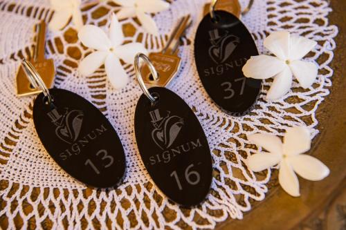 three tags on a table with white flowers on it at Hotel Signum in Malfa