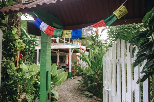 a fence with prayer flags in front of a house at Casa BOHÖ in Puerto Viejo