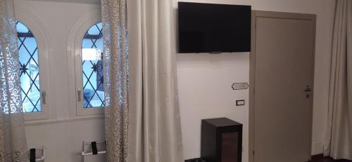 a room with two windows and a flat screen tv at "La Selvetta" bed and breakfast in Buguggiate