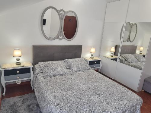 una camera da letto con un letto e due specchi sul muro di Fabuloso Apartamento con Terraza y Piscina a Villabáñez