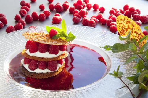 a cake with strawberries on top on a white plate at L'Oustal Del Barry in Najac