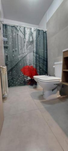 a bathroom with a toilet and a red umbrella at Centro Carlos Paz 1 dormitorio in Villa Carlos Paz