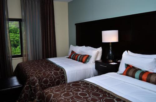 a hotel room with two beds and a window at Staybridge Suites North Jacksonville by IHG in Jacksonville