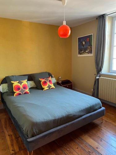 a bedroom with a bed with colorful pillows on it at Maison d'hôtes de la prison en toutes libertés in Espalion