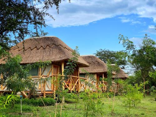 a couple of huts with thatched roofs at Murchison Falls Bamboo Village in Murchison Falls National Park