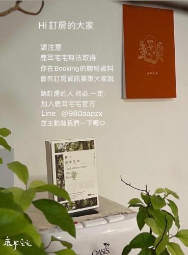 a sign on a wall above a computer with a plant at 鹿耳宅宅 Lure Guesthouse in Tainan