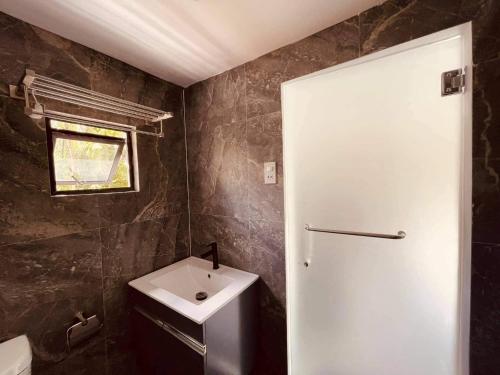 a bathroom with a white door and a sink at A House Lucban Resort & Spa in Tayabas