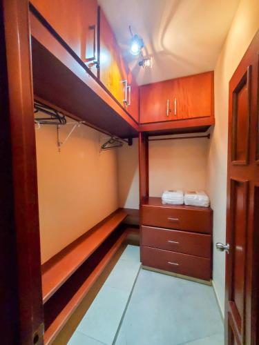 a small room with wooden cabinets and a closet at Casa Linda beautiful Villa in Sosúa