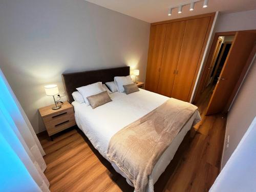 a bedroom with a large bed and a wooden floor at P&C Areny in Canillo