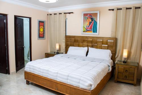 1 dormitorio con 1 cama grande, 2 mesitas de noche y 2 lámparas en Casa Linda beautiful Villa, en Sosúa