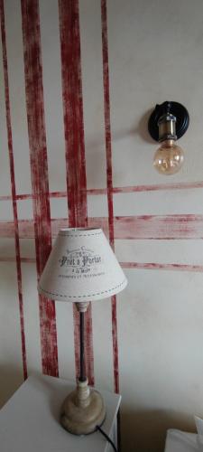 a lamp on a table with a red and white wall at Les 4 Saisons in Kruth