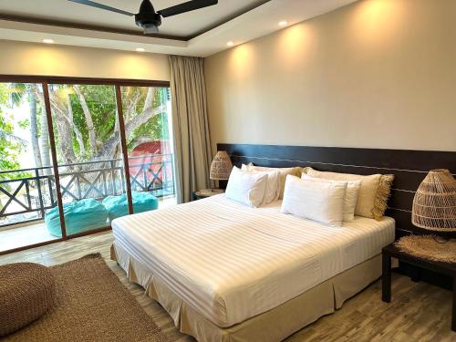 a bedroom with a bed and a large window at Canopus Retreat Thulusdhoo in Thulusdhoo