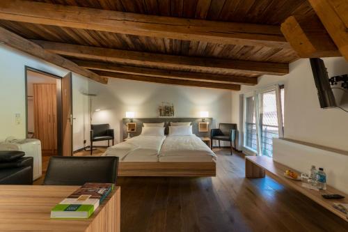 Schlafzimmer mit einem großen Bett und Holzdecken in der Unterkunft Hotel zur Kloster-Mühle in Groß Meckelsen