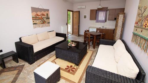a living room with a couch and a table at Ξενώνας Μενελαΐς - Menelais Apartments in Thrapsímion