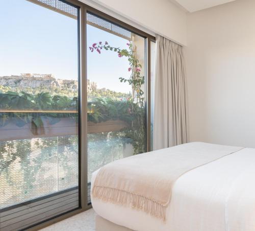 una camera da letto con un letto e una grande finestra di Altar Suites ad Atene