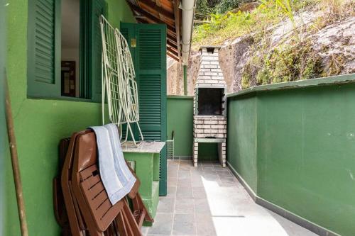 a green building with a bench and a stair case at Delba Costa Smeralda - Barra do Una in Barra do Una