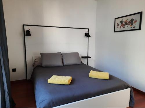 - une chambre avec un lit doté de 2 oreillers jaunes dans l'établissement Ty Nevet - Appartement avec balcon et parking privé, à Quimper