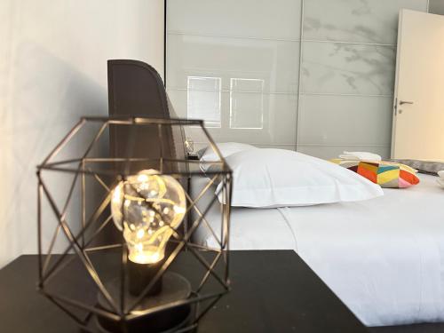 um quarto com uma cama e uma mesa com um candeeiro em FEEL - Casa di Luce em Bérgamo