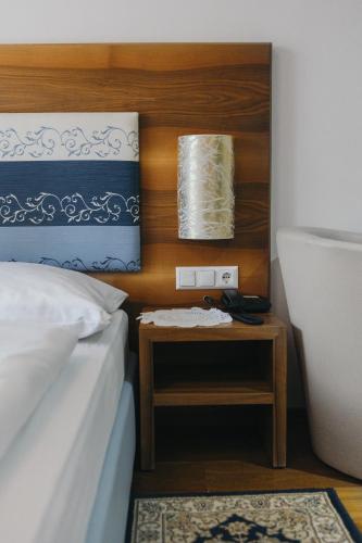 a bedroom with a bed and a side table with a phone at Hotel Paradiesquelle in Puchberg am Schneeberg