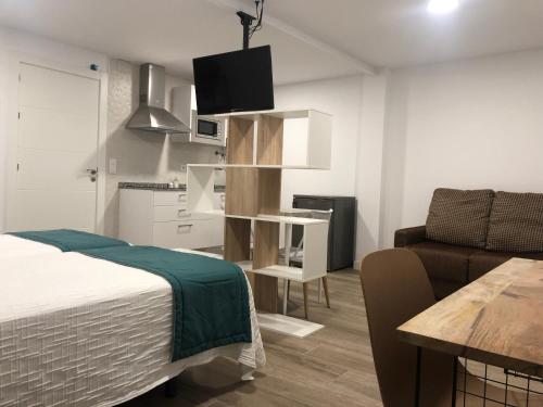 a bedroom with a bed and a couch and a table at RoomConcept Hostel in Santo Domingo de la Calzada