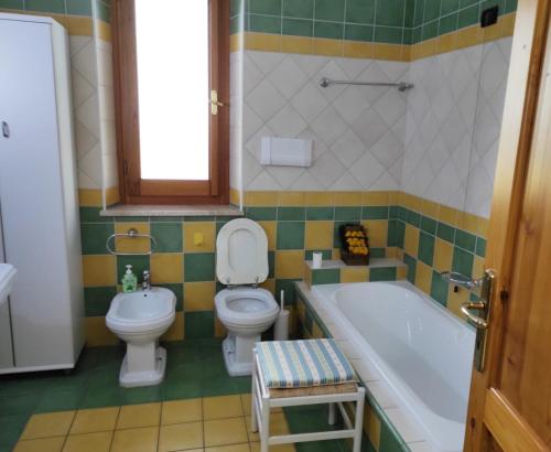 e bagno con servizi igienici, vasca e lavandino. di Casa Lupino a Orosei