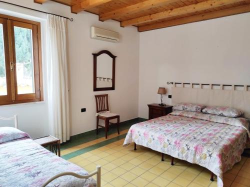 een slaapkamer met 2 bedden en een spiegel bij Casa Lupino in Orosei